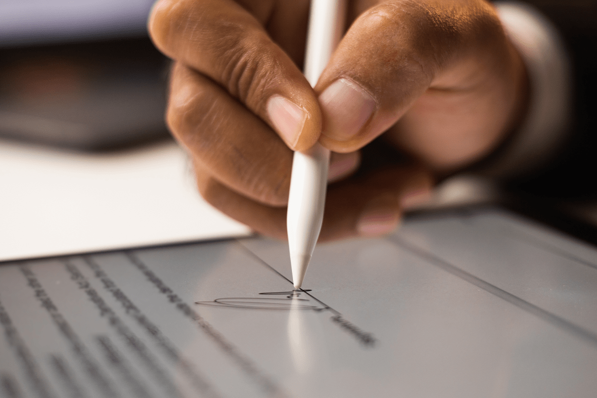 7 ways for businesses to reduce waste_signing a contract with an electronic signature on a tablet_visual 2