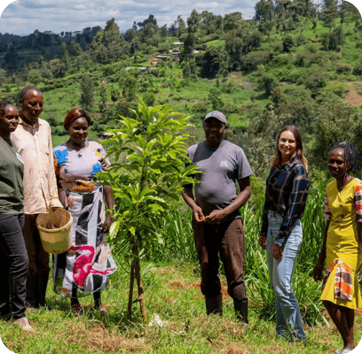 a group of people standing next to a planted tree