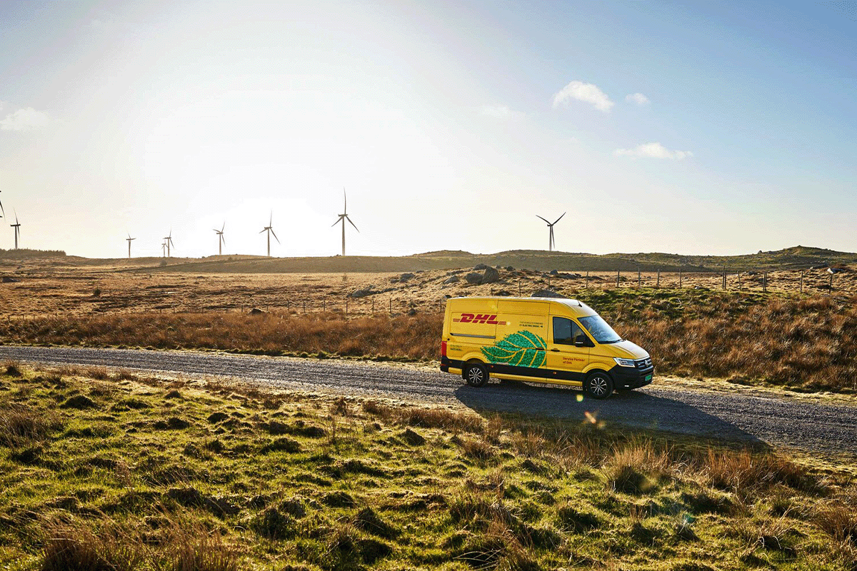 Industry carbon footprints_DHL delivery truck, wind turbines in the background_visual 3