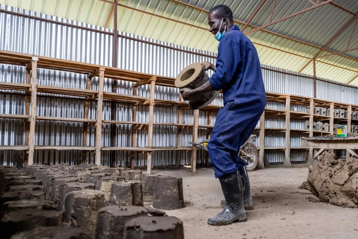 Local production, global purpose_a behind-the-scenes look at cookstove production_Artisan in a cookstove factory preparing cookstoves for drying_visual 2