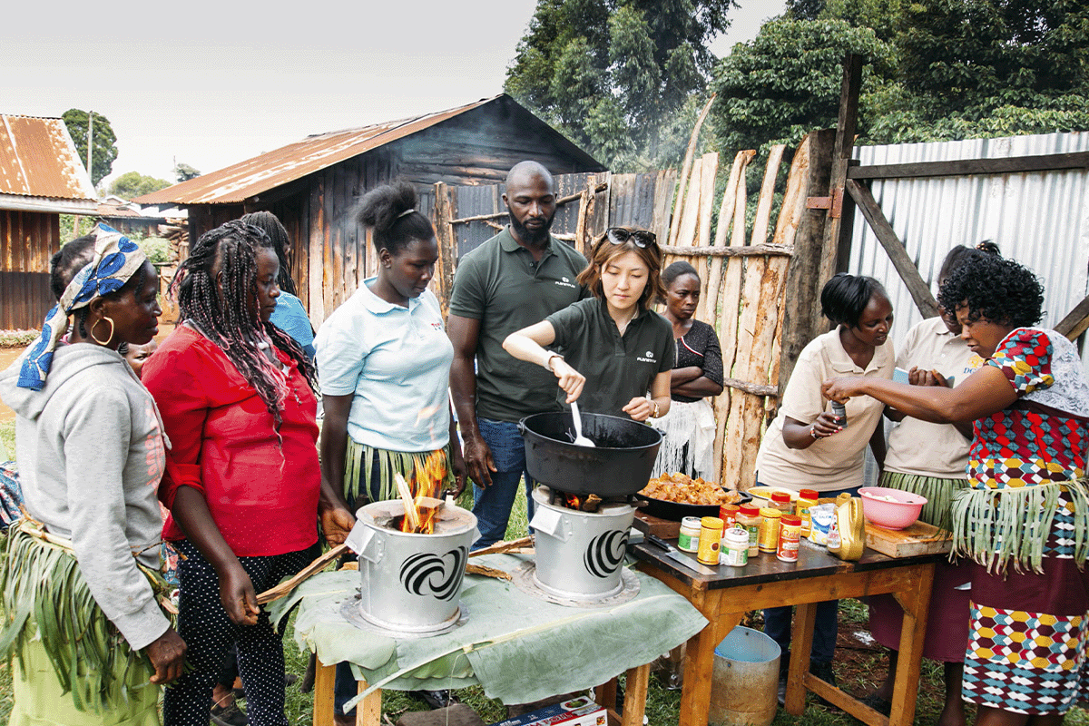 Making a green difference through gaming_Planet Play members with a local people cooking, using energy efficient cookstoves_visual 2