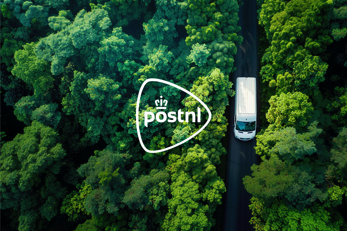 PostNL_ driving forward sustainable logistics_Aerial view of a delivery car driving on a road along a green deciduous forest_visual 1