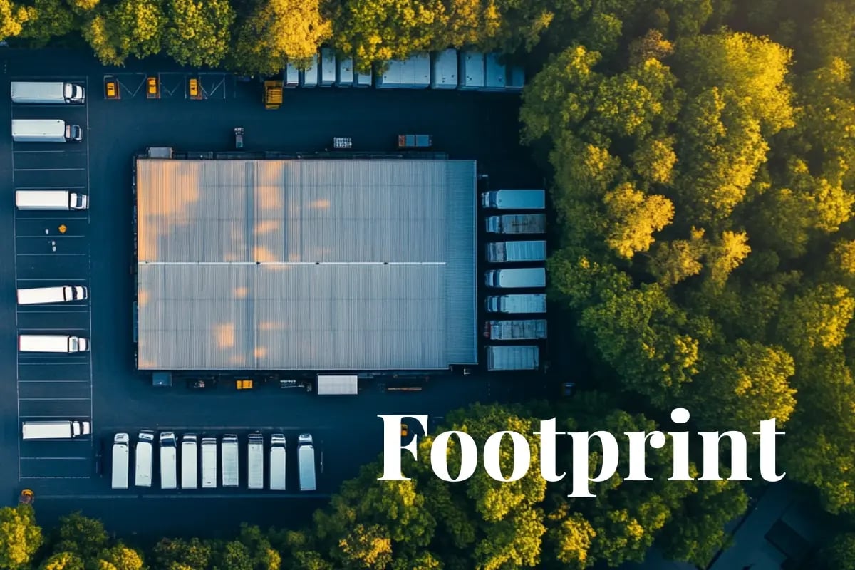 Why scope 3 emissions are your biggest blind spot—and what to do about it_Aerial view of a large warehouse and delivery trucks, illustrating a modern supply chain in operation_visual 1